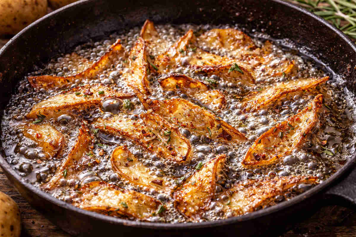 Bucce patate che friggono nell'olio bollente