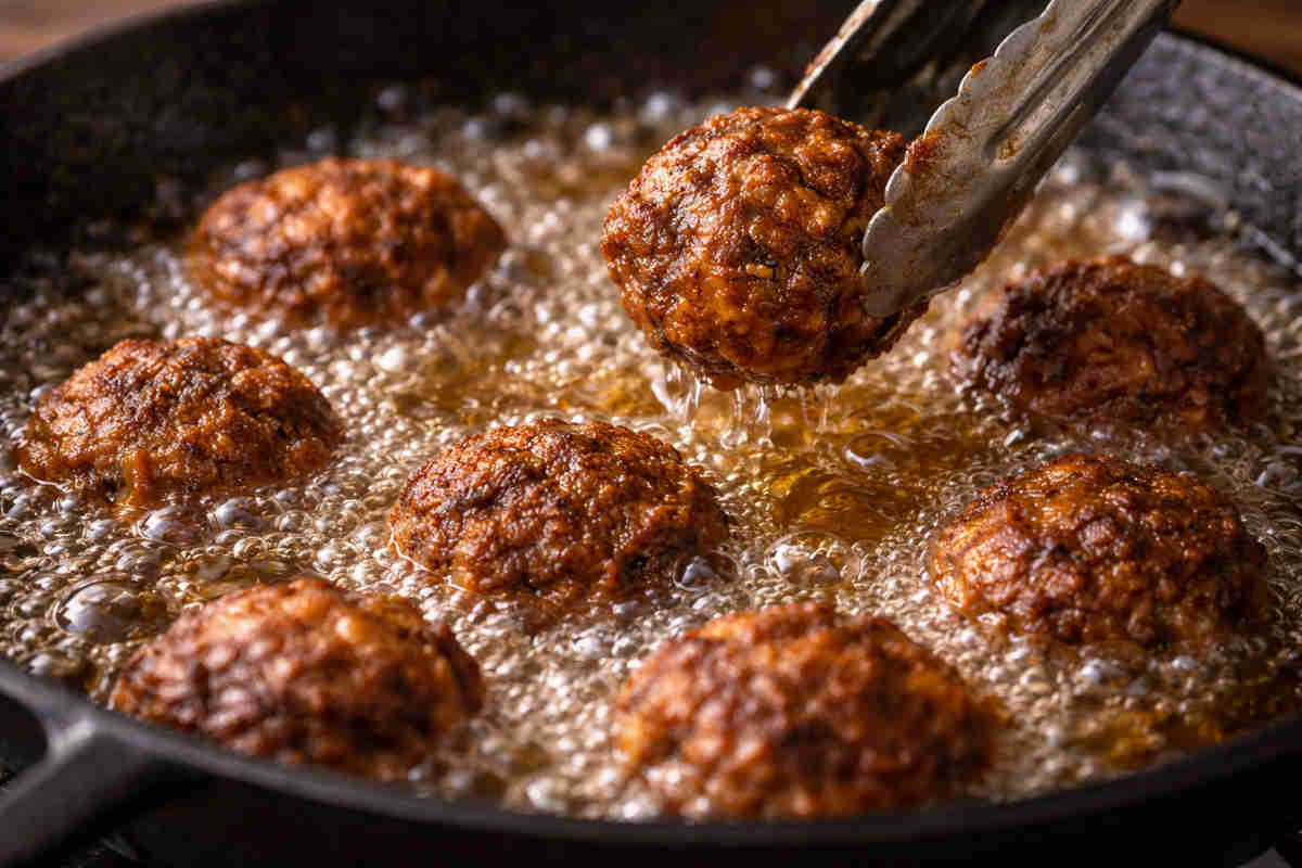 Polpette di carne che friggono in olio bollente